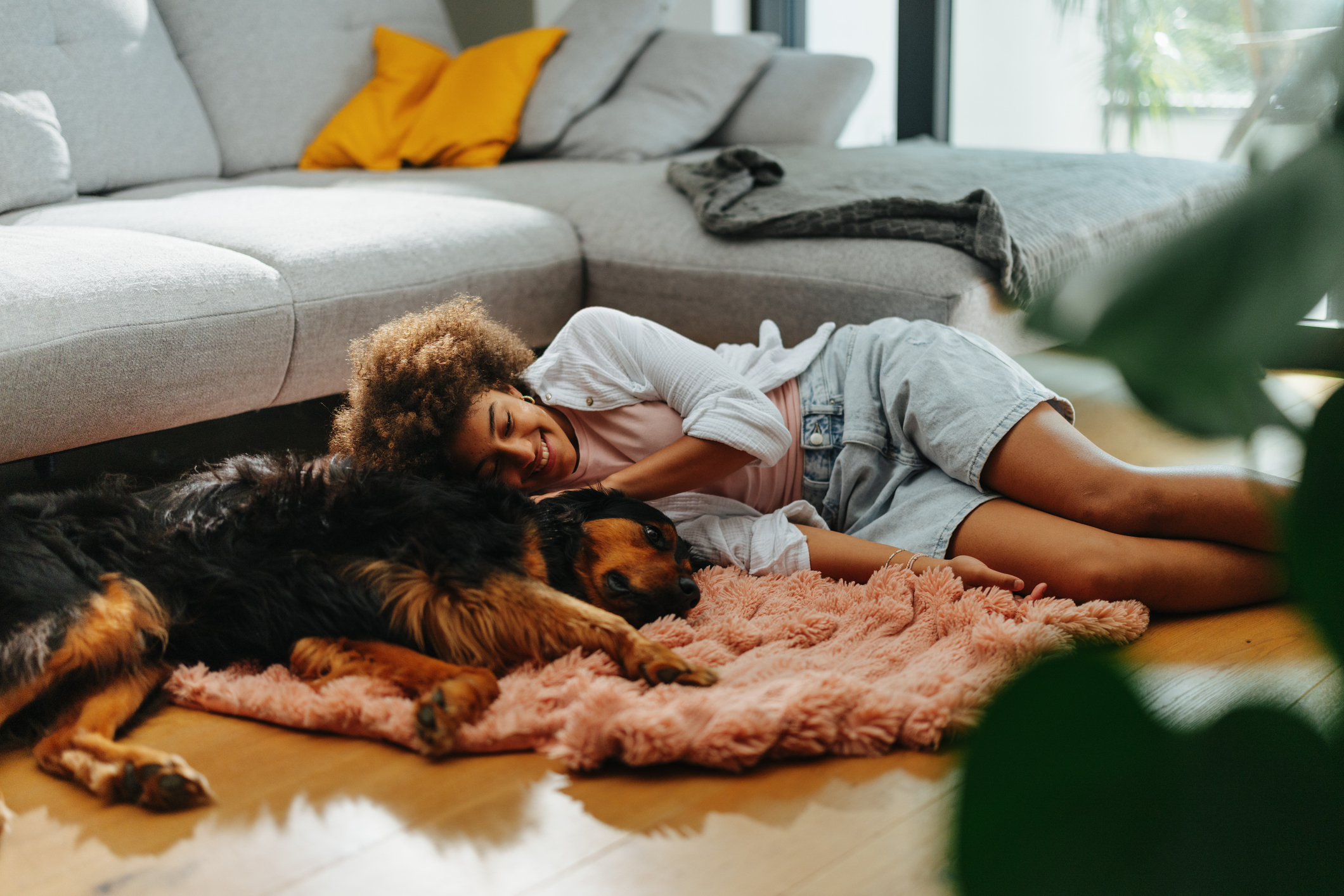 Teenager laying with her senior dog on the living room floor